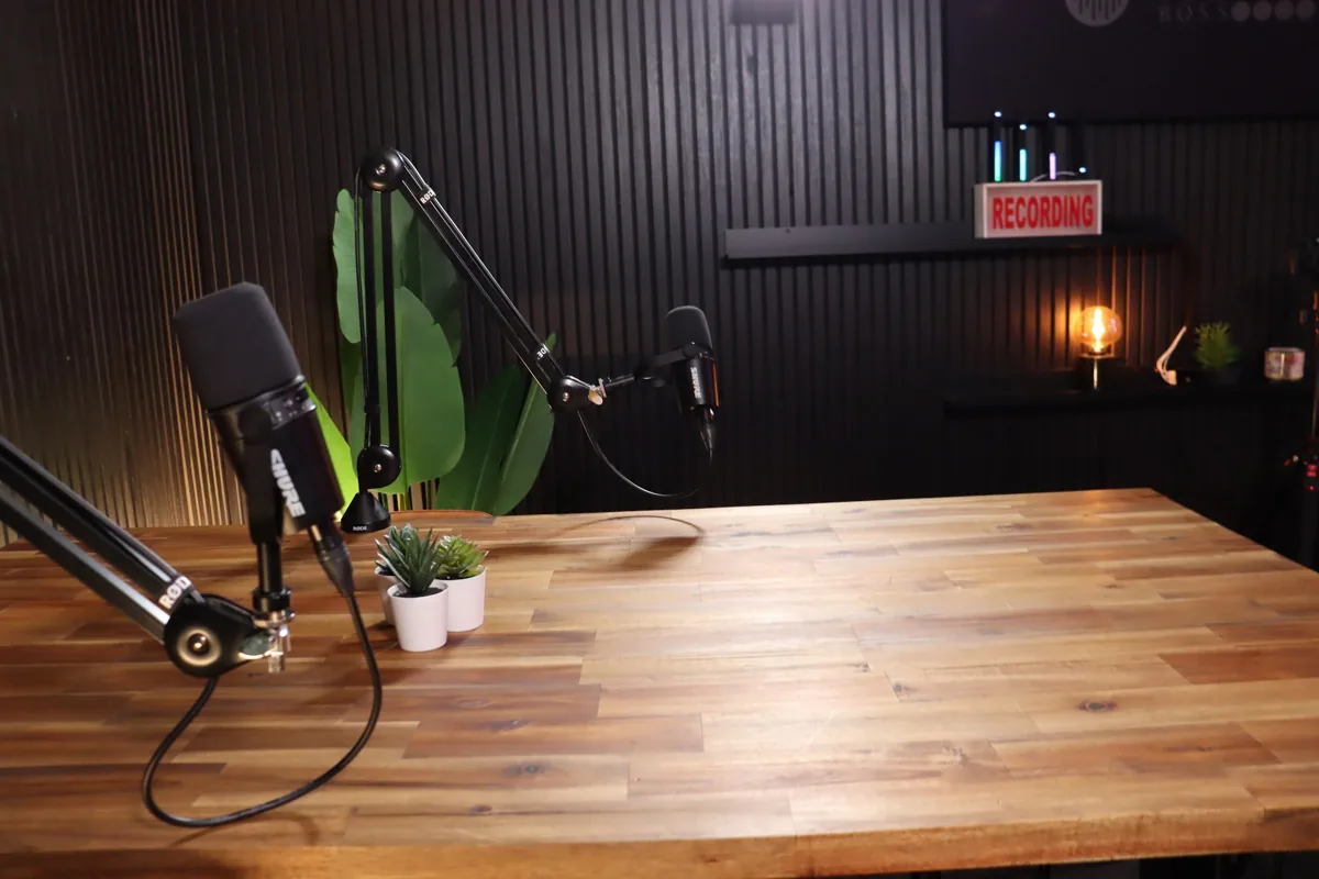 Timber podcast desk with boom-arm microphones ready for a two-person recording