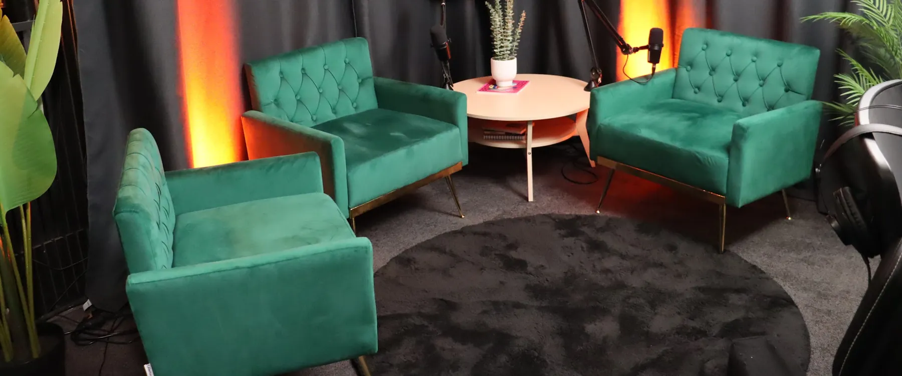 Three green velvet armchairs around a round table, boom mics ready, in our Brisbane partner podcast studio
